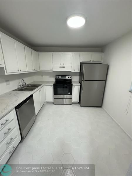 a kitchen with a cabinets and white appliances