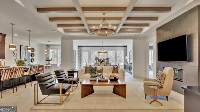 a living room with furniture a flat screen tv and kitchen view