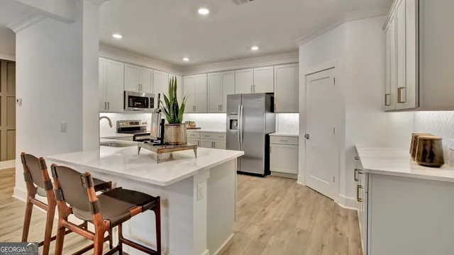 a kitchen with kitchen island a stove a table and chairs in it