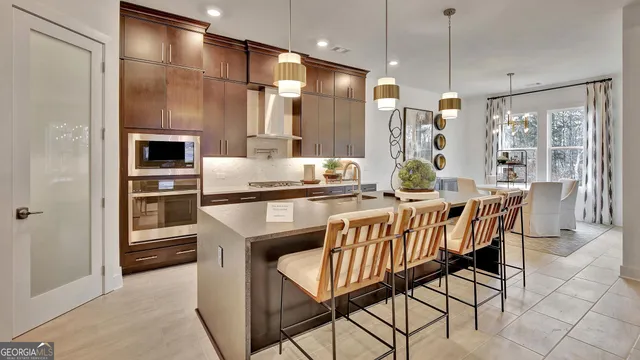 a kitchen with a table chairs refrigerator and cabinets