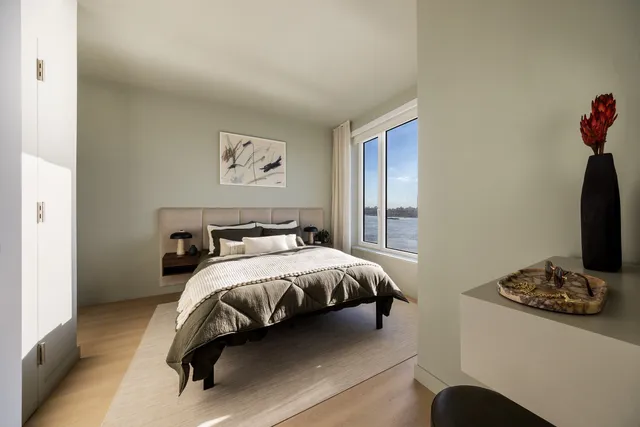 a bedroom with a bed and a potted plant