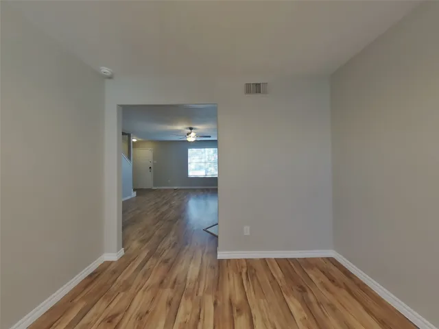 a view of a room with wooden floor and a window