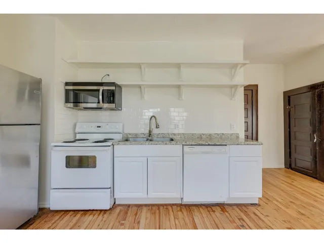 a kitchen with stainless steel appliances a stove a sink and a refrigerator
