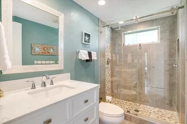 a bathroom with a sink a toilet and shower