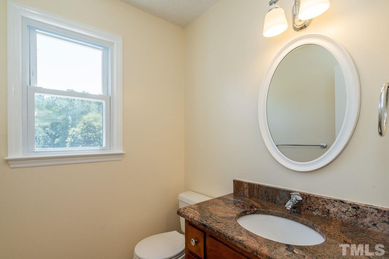 9320 Tallgrass Road Raleigh, NC 27603 - Photo 12 of 28 a bathroom with a toilet mirror vanity and a sink