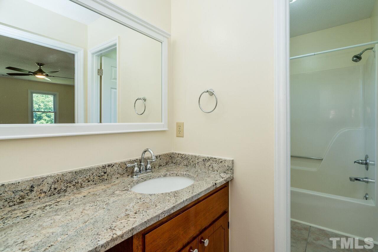 9320 Tallgrass Road Raleigh, NC 27603 - Photo 17 of 28 a bathroom with a granite countertop sink and a mirror