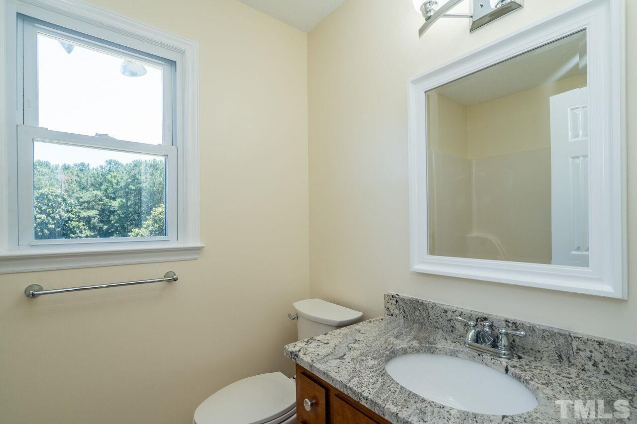 9320 Tallgrass Road Raleigh, NC 27603 - Photo 19 of 28 a bathroom with a granite countertop sink toilet and mirror