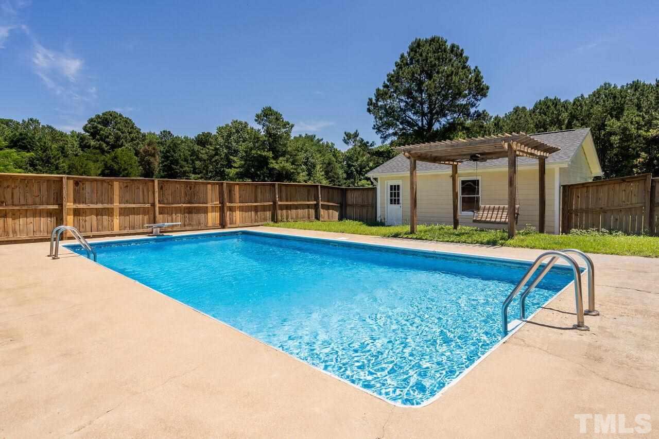 9320 Tallgrass Road Raleigh, NC 27603 - Photo 23 of 28 a view of a house with swimming pool and a yard