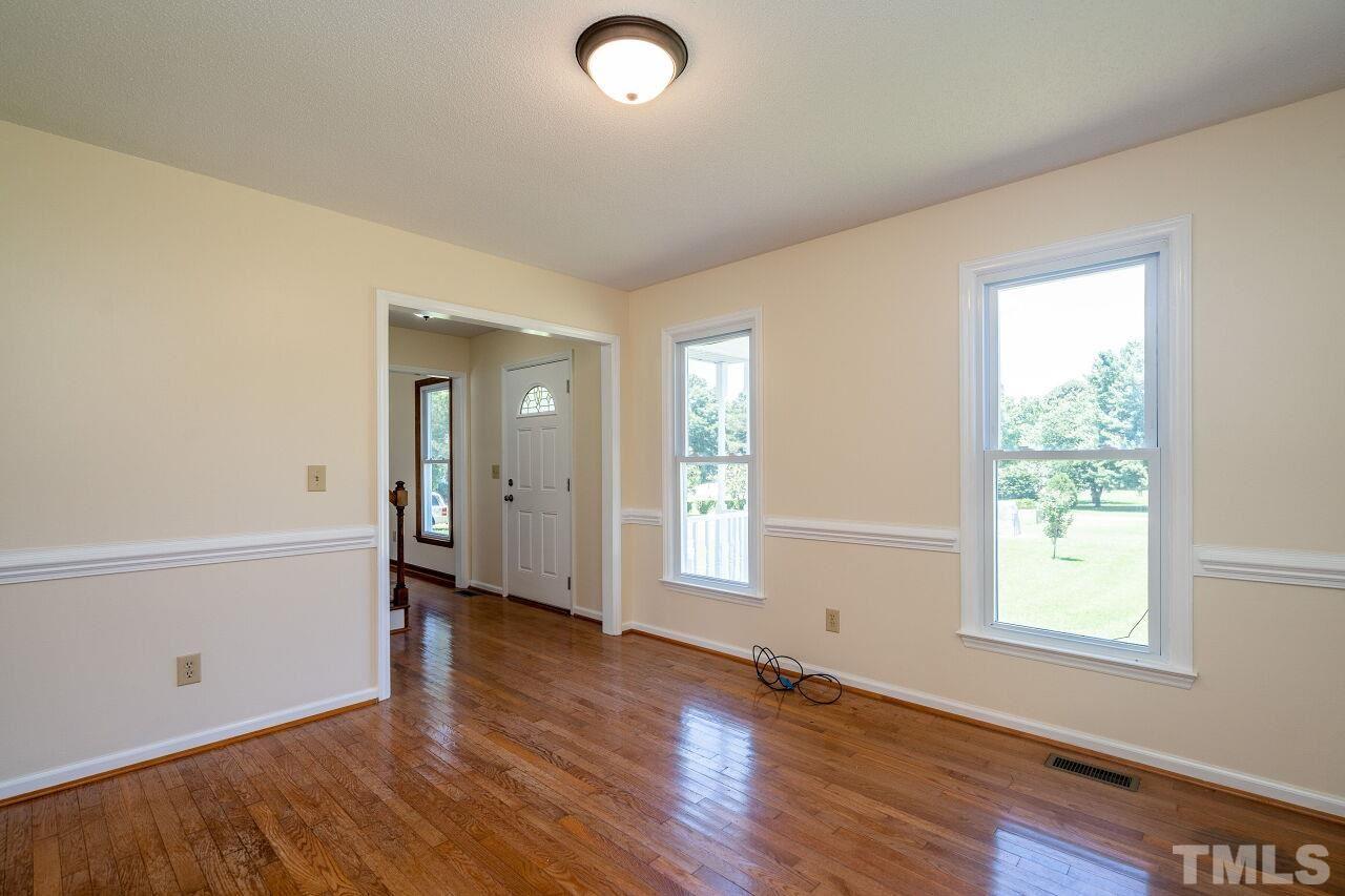 9320 Tallgrass Road Raleigh, NC 27603 - Photo 4 of 28 a view of an empty room with wooden floor and a window