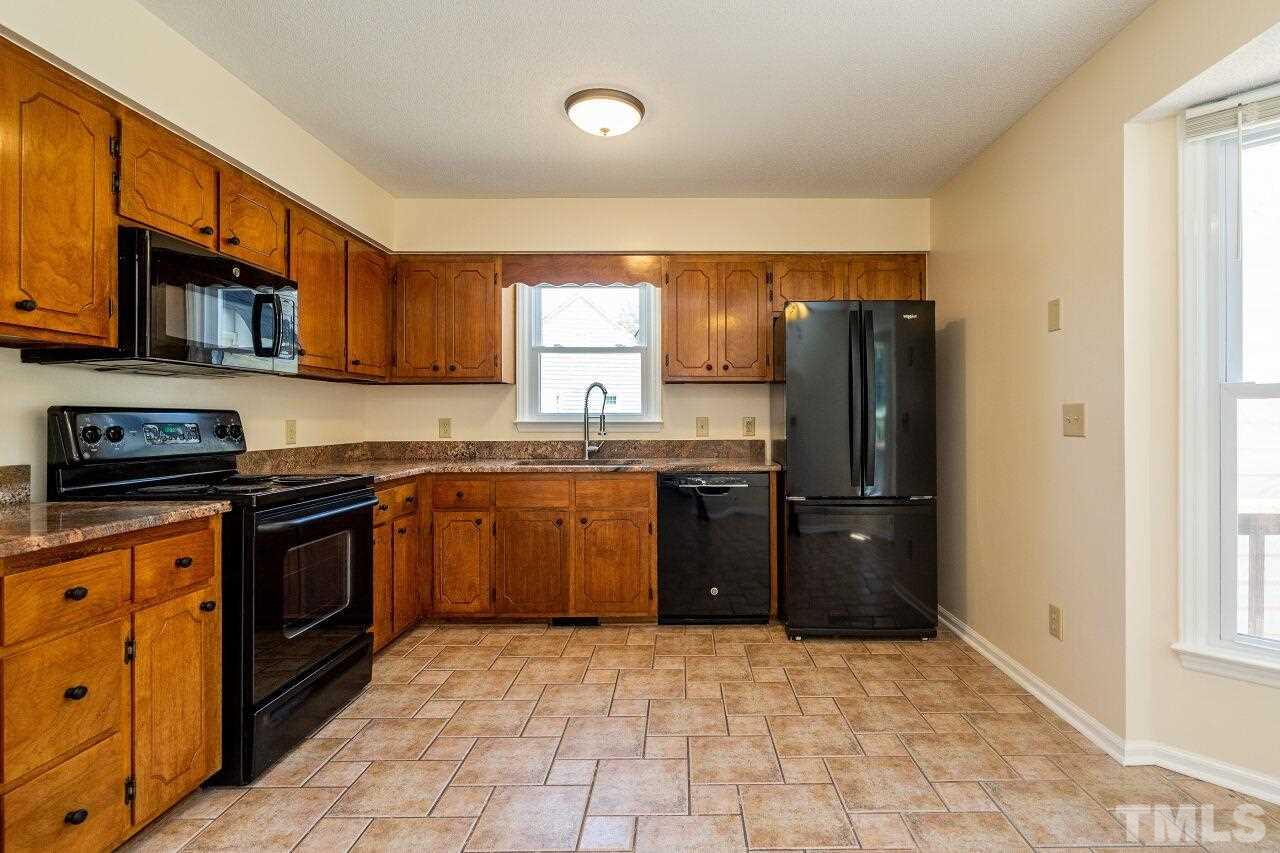 9320 Tallgrass Road Raleigh, NC 27603 - Photo 9 of 28 a kitchen with stainless steel appliances granite countertop a refrigerator stove top oven a sink and dishwasher