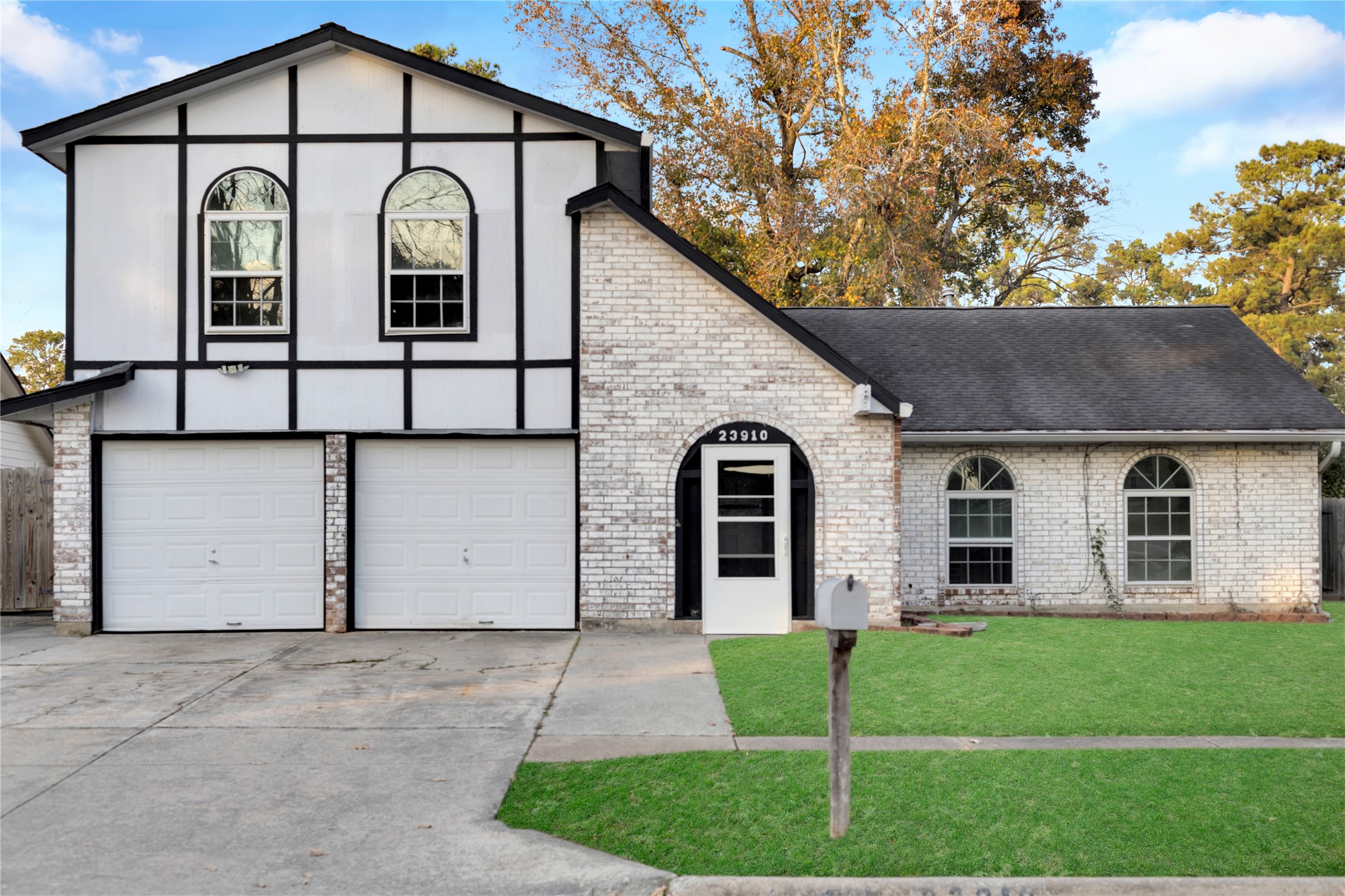 a view of a white house with large windows and a small yard
