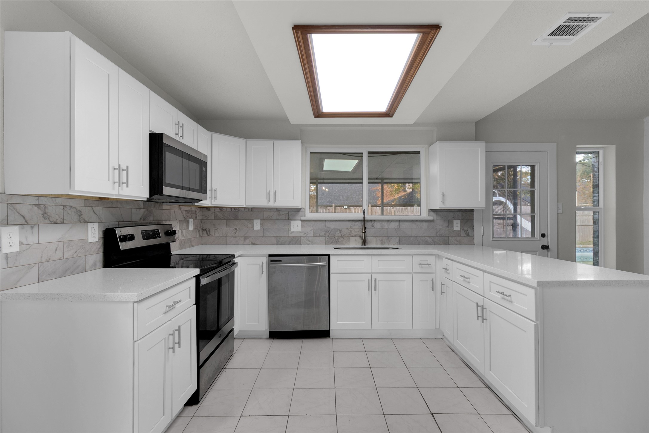 23910 Spring Briar Lane Spring, TX 77373 - Photo 12 of 38 a kitchen with cabinets appliances a sink and a window