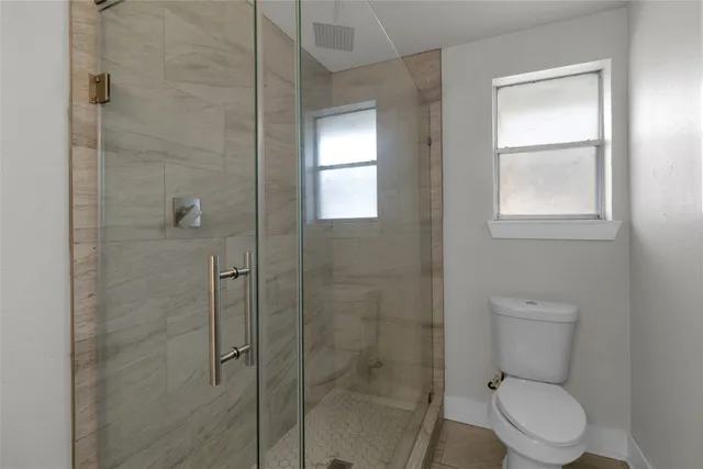 a bathroom with a toilet and a shower