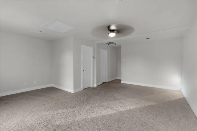 an empty room with a ceiling fan and a window