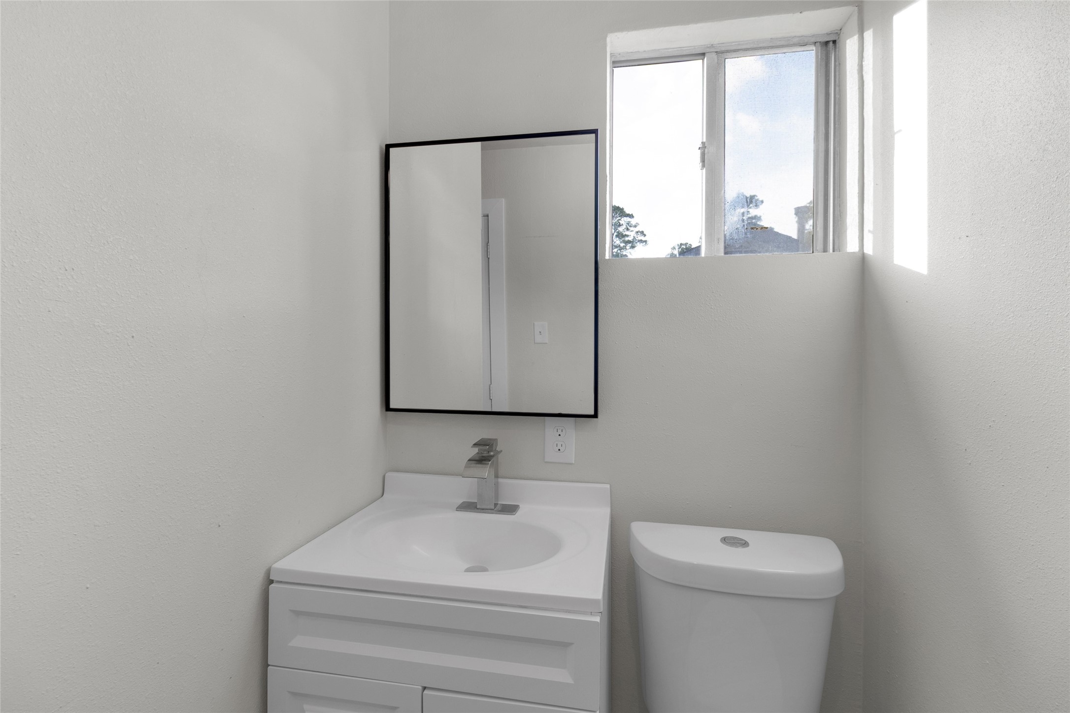 23910 Spring Briar Lane Spring, TX 77373 - Photo 33 of 38 a bathroom with a toilet sink vanity and a window