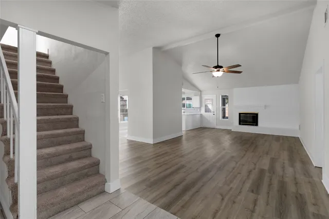 a view of a livingroom with wooden floor and a ceiling fan