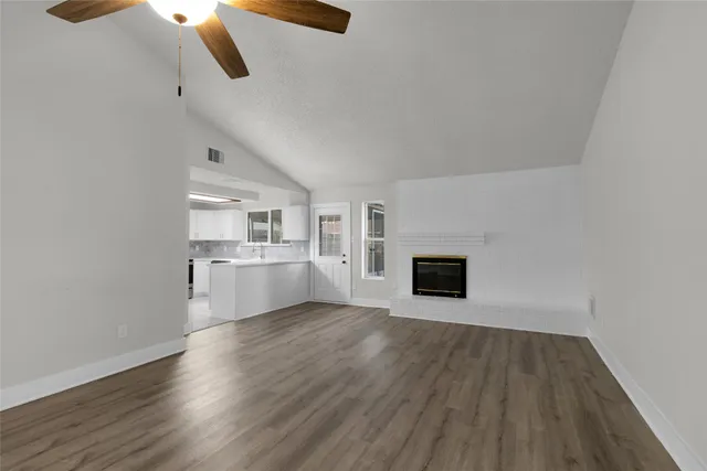 a view of a kitchen with wooden floor and a fireplace