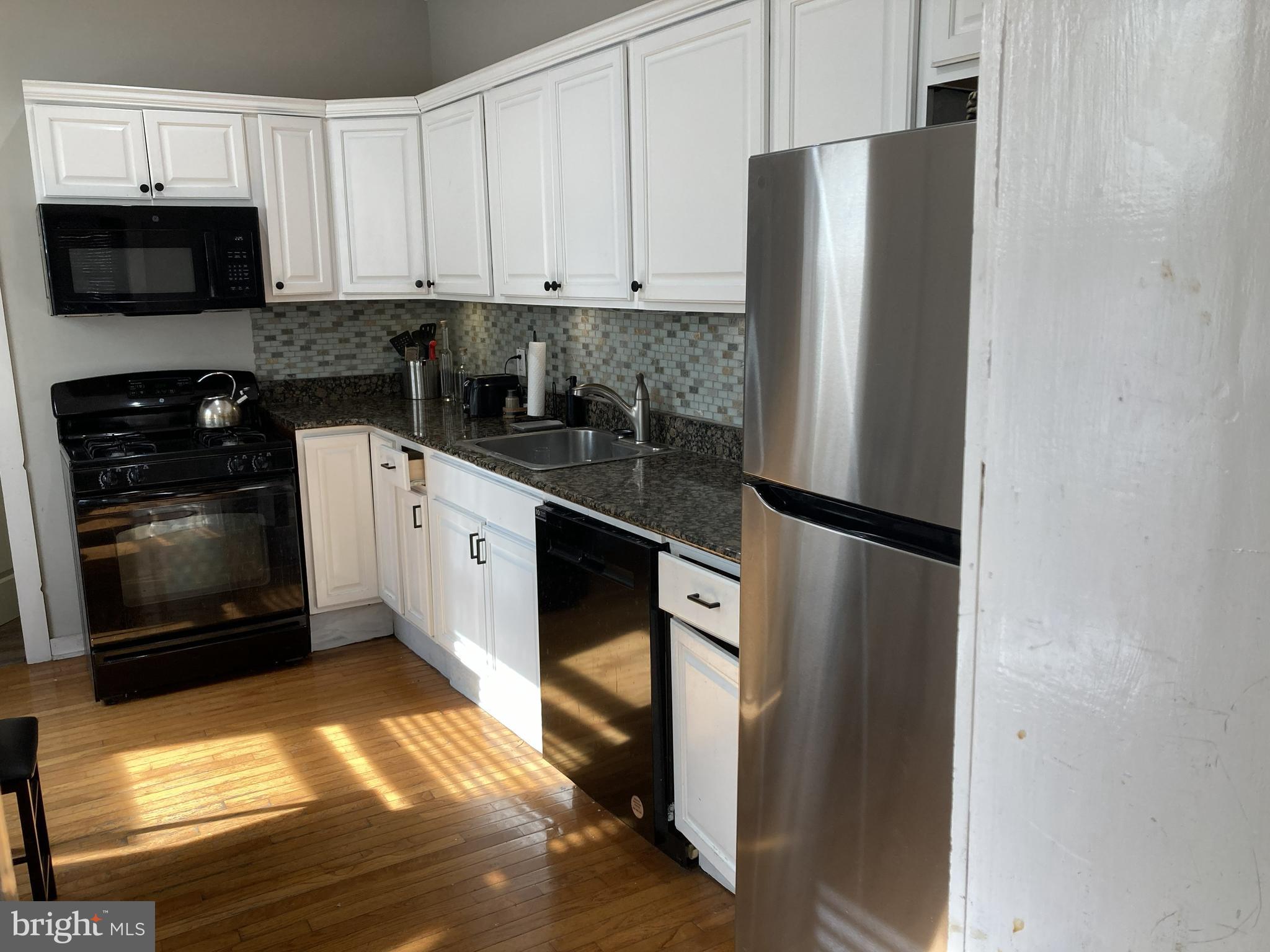 1304 Marlborough Street Philadelphia, PA 19125 - Photo 6 of 19 a kitchen with stainless steel appliances a refrigerator a stove a microwave and cabinets