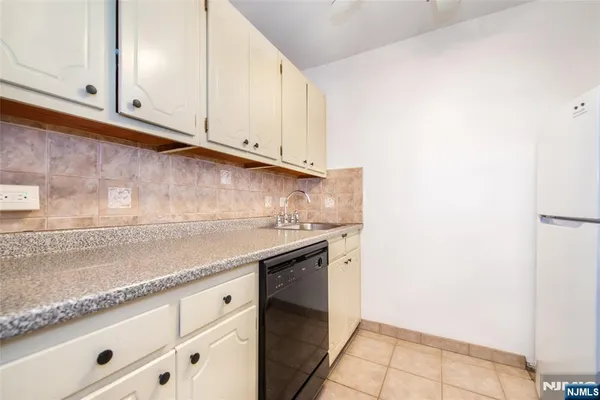 a kitchen with granite countertop white cabinets and a sink