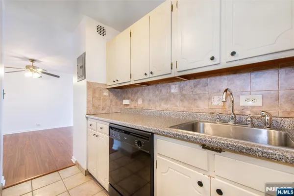 a kitchen with granite countertop white cabinets and sink