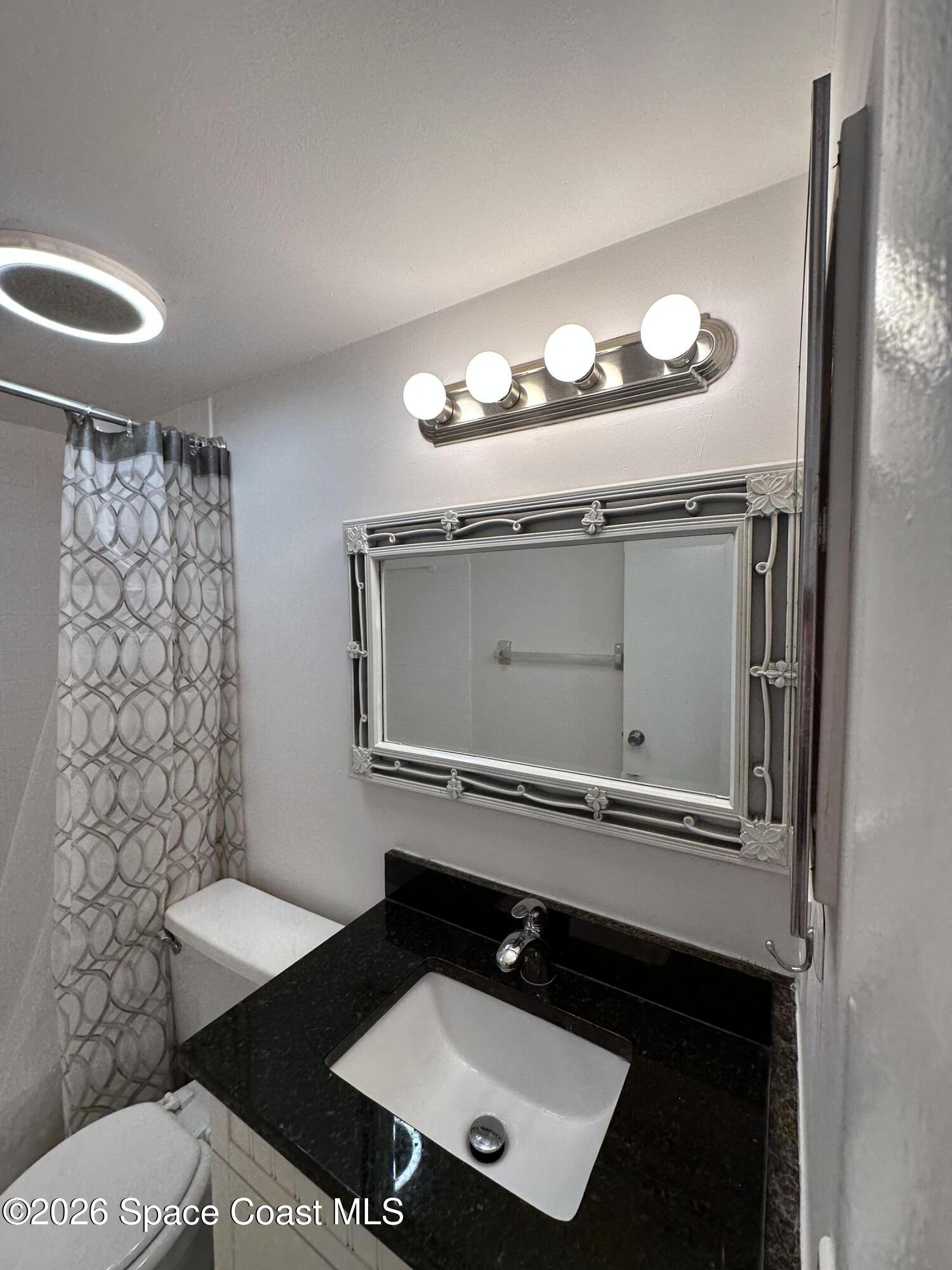 837 Hickory Street, Unit 3 Melbourne, FL 32901 - Photo 23 of 24 a bathroom with a sink and a mirror
