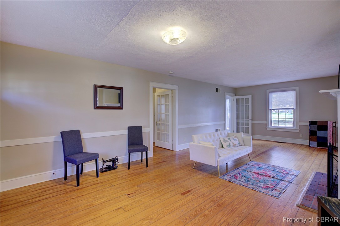 10371 Buckley Hall Road Mathews, VA 23109 - Photo 14 of 28 Sitting room with baseboards, a textured ceiling, and light wood-style floors