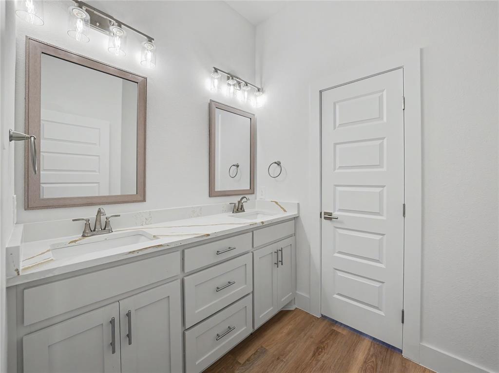 328 Slimp Bluff Azle, TX 76020 - Photo 25 of 30 Dual vanity with light gray cabinetry, white countertops, and wood-finish flooring
