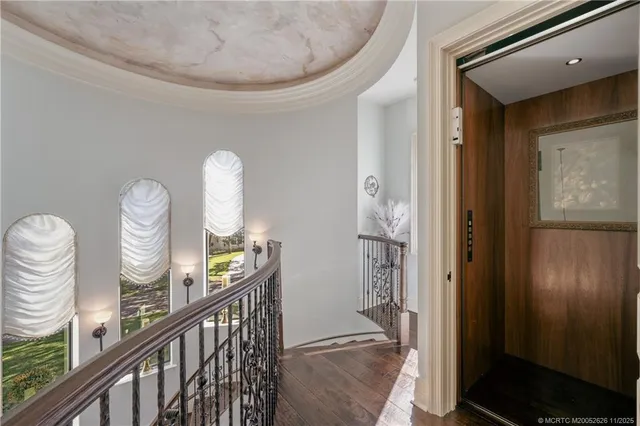 a view of a hallway with wooden floor and windows
