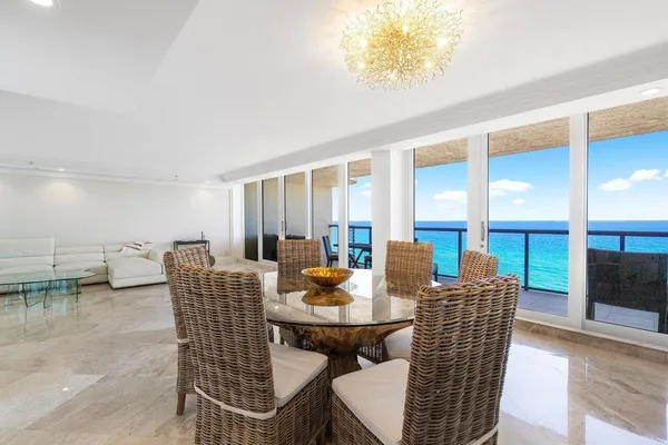 a kitchen with a stove a sink a refrigerator and chairs