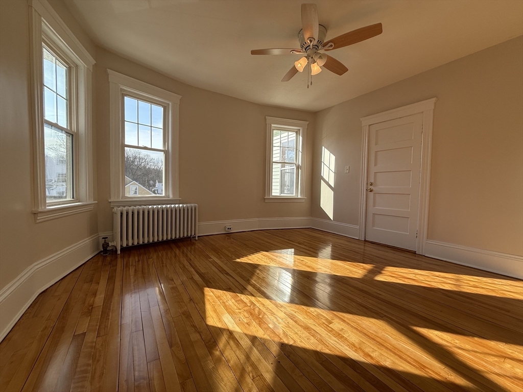 304 Lovell Street, Unit 2 Worcester, MA 01602 - Photo 2 of 13 a view of an empty room with wooden floor and a window