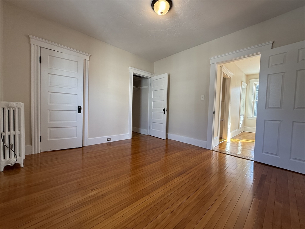304 Lovell Street, Unit 2 Worcester, MA 01602 - Photo 9 of 13 an empty room with wooden floor and windows