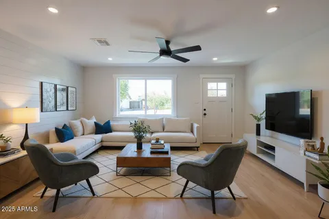 a living room with furniture a window and a flat screen tv