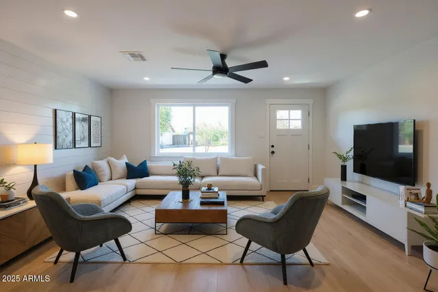 a living room with furniture a window and a flat screen tv