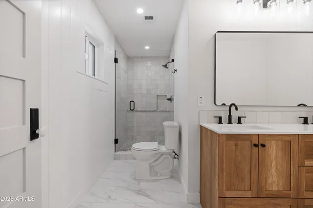 a bathroom with a sink a toilet and shower