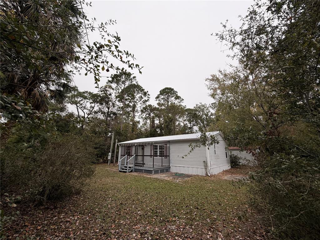 212 Paradise Shores Road Crescent City, FL 32112 - Photo 4 of 23 a house with trees in the background