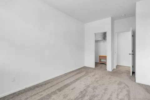 a bedroom with a bed and dresser with chair