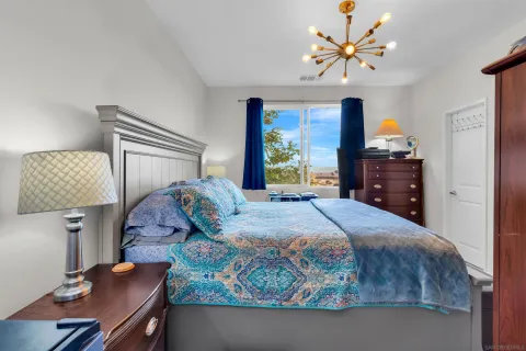 a bedroom with a bed and a refrigerator