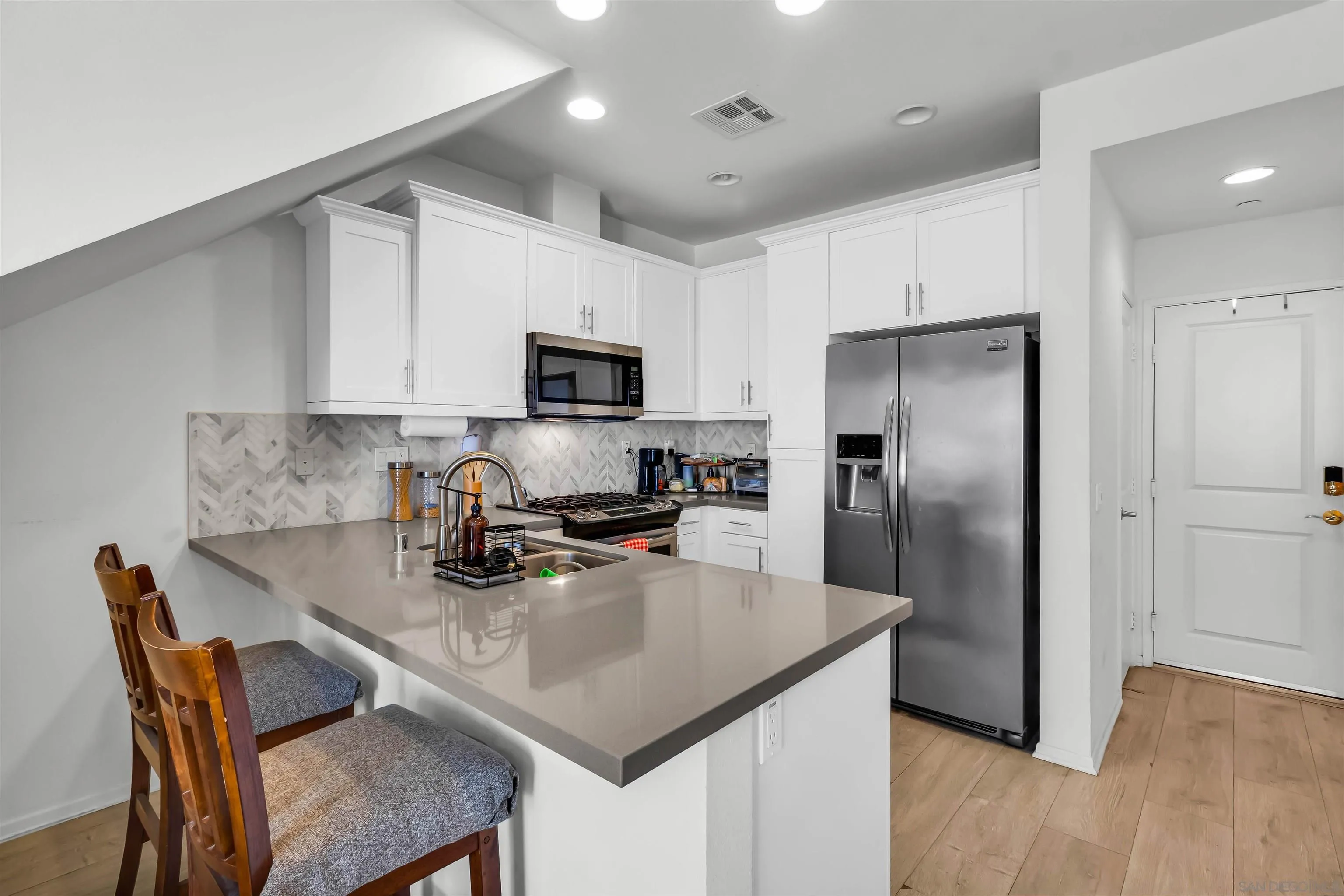 5515 San Roberto San Diego, CA 92154 - Photo 7 of 27 a kitchen with stainless steel appliances granite countertop a refrigerator a stove a sink a dining table and chairs