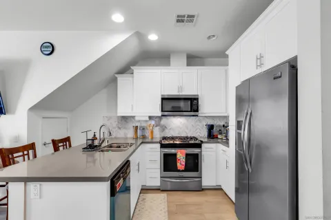 a kitchen with kitchen island a sink stainless steel appliances and cabinets