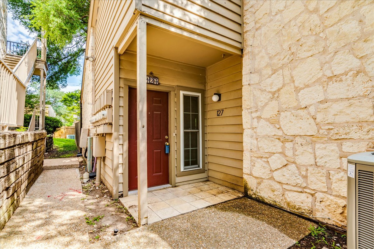 3809 Spicewood Springs Road, Unit 127 Austin, TX 78759 - Photo 2 of 29 A welcoming front entrance featuring natural stone accents and classic siding.
