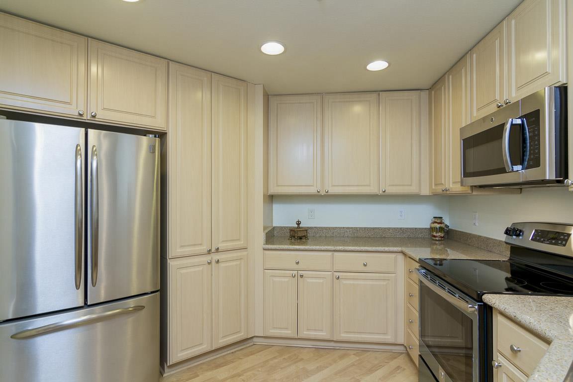 1883 Agnew Road, Unit 428 Santa Clara, CA 95054 - Photo 4 of 8 a kitchen with white cabinets stainless steel appliances and a refrigerator