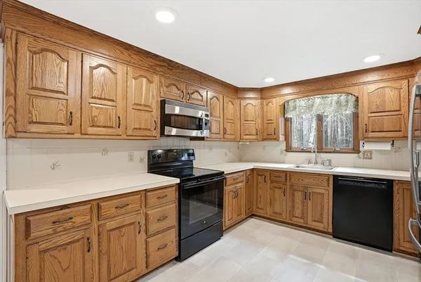a kitchen with stainless steel appliances granite countertop a sink dishwasher stove and microwave