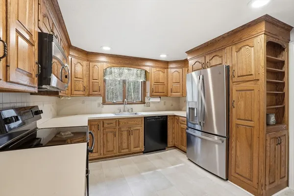 a kitchen with stainless steel appliances granite countertop a refrigerator and a sink