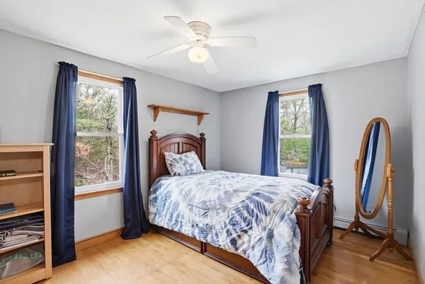 a bedroom with a bed next to a window with a flat tv screen tv and a window