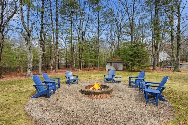 a backyard of a house with fountain table and chairs