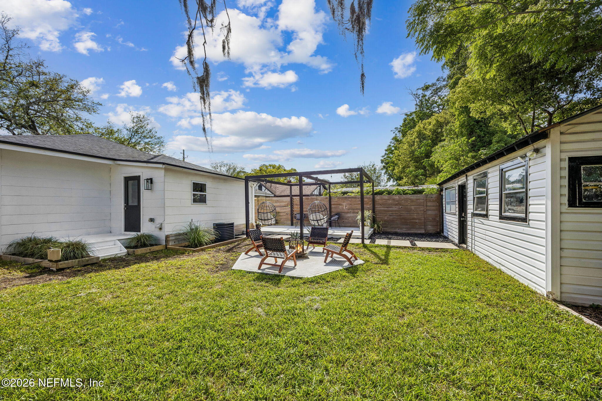 4713 French Street Jacksonville, FL 32205 - Photo 46 of 74 a view of a backyard with table and chairs and a large tree