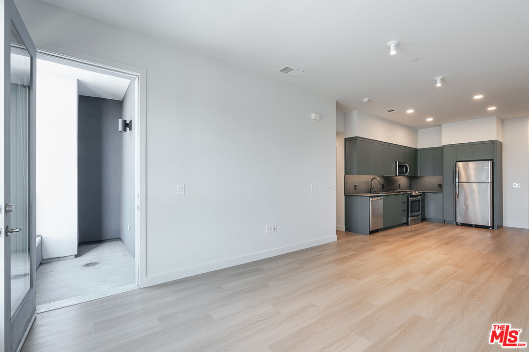10601 Washington Boulevard, Unit 232 Culver City, CA 90232 - Photo 6 of 30 a view of kitchen with stainless steel appliances kitchen island wooden floor and living room