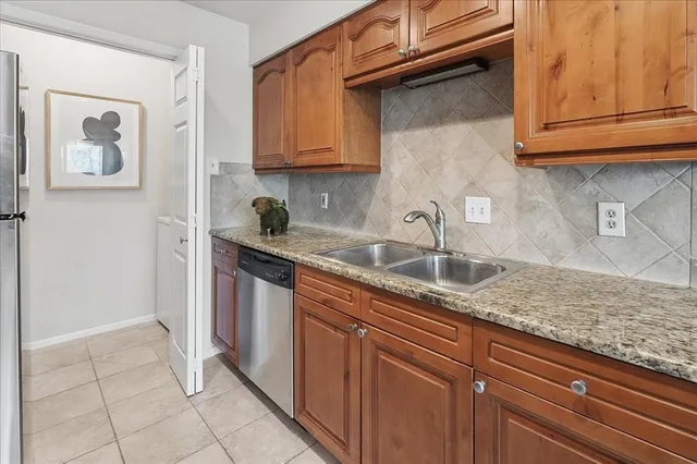 a kitchen with stainless steel appliances granite countertop a sink and a white cabinets