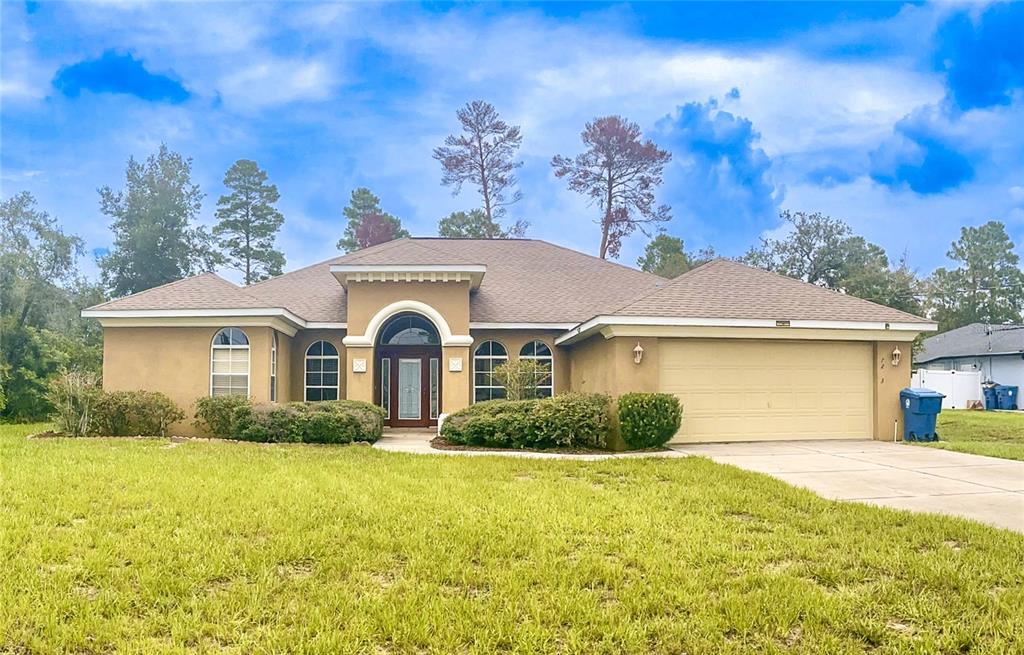 7243 Bahama Swallow Avenue Weeki Wachee, FL 34613 - Photo 1 of 18 a front view of a house with a garden