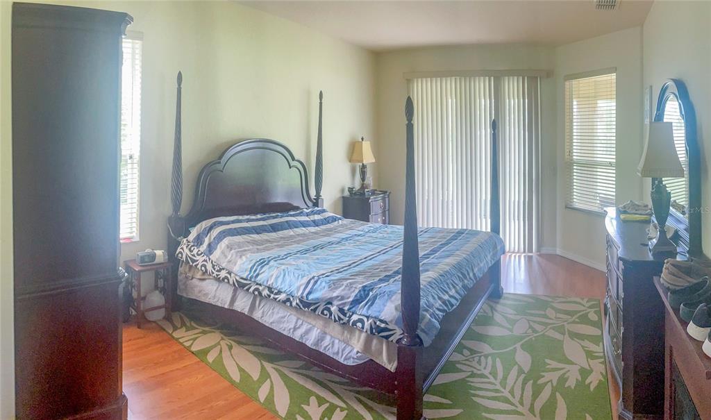 7243 Bahama Swallow Avenue Weeki Wachee, FL 34613 - Photo 12 of 18 a bedroom with a bed lamp and a large window